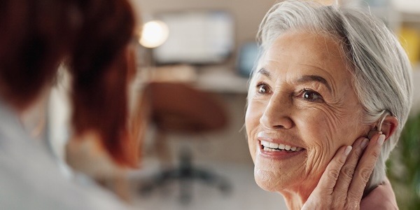 Doctor, senior woman and hearing aid in clinic for geriatric support, tinnitus and help for sound waves. Ent, otolaryngology and patient with cochlear implant for audio, healthcare and auditory tech Doctor, senior woman and hearing aid in clinic for geriatric support, tinnitus and help for sound waves. Ent, otolaryngology and patient with cochlear implant for audio, healthcare and auditory tech